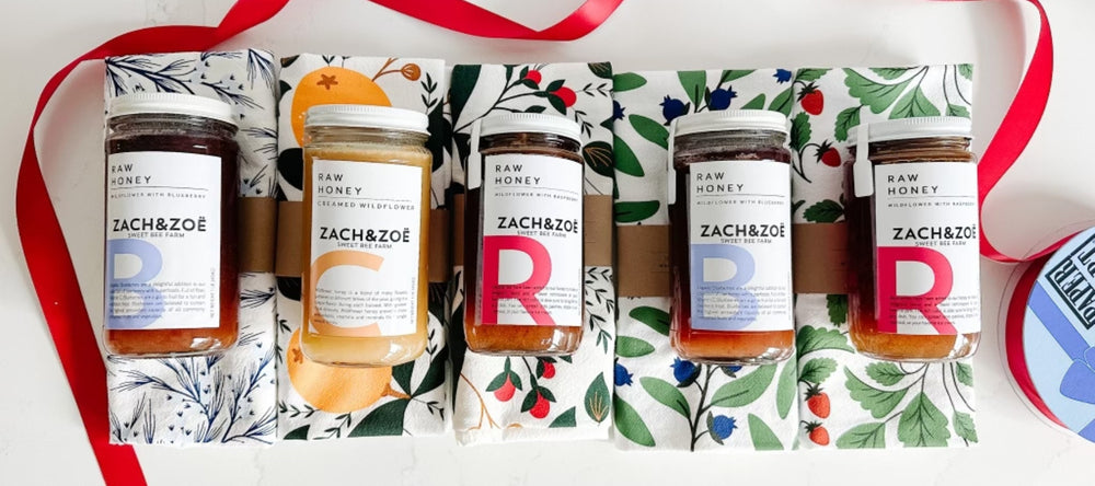 Employee appreciation gifts that include different flavors of Zach & Zoe honey paired with different berry tea towels from Hazelmade.