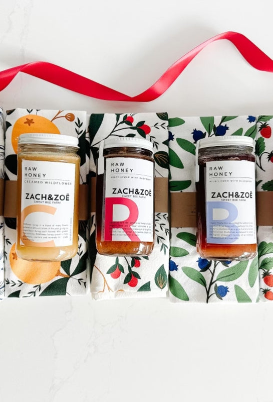 An event welcome gift by East Third Collective and includes Zach and Zoe honey and Hazelmade tea towels.