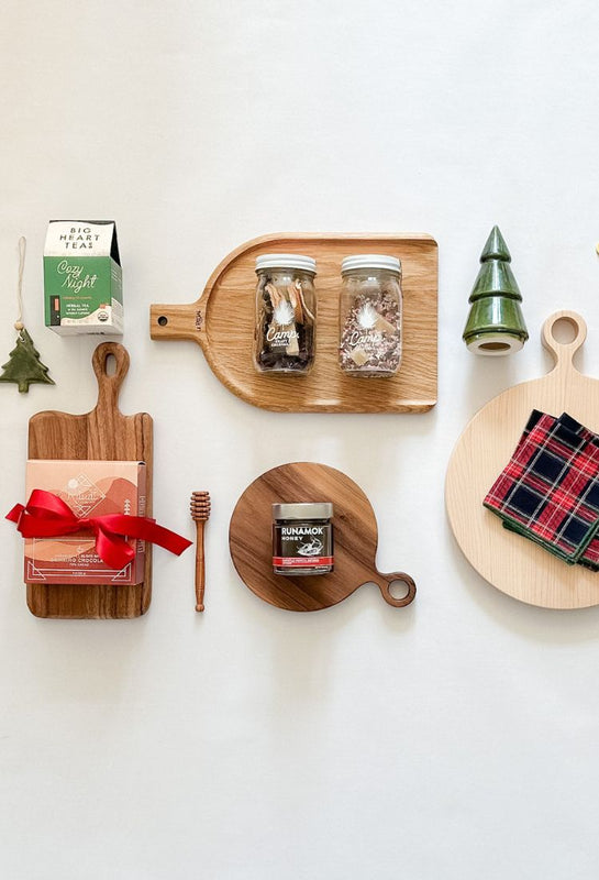 A collection of boards and festive gift from East Third Collective. Holiday candles, chocolate, tartan napkins and ceramic holiday tree.