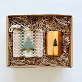Skeem sweet balsam candle paired with a pretty kitchen textile from Kate Kilmurray and a green ceramic tree ornament.