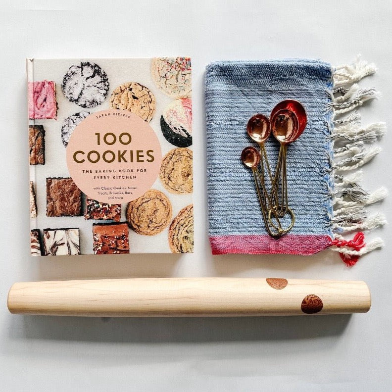 100 Cookies cookbook paired with a beautiful rolling pin from Untitled Co, copper meansuring spoons and a pretty kitchen towel.