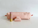 Small Anchal toiletry bag in a pale pink paired with a hair claw and lip tint in the same shades of pink. 