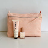 Pale pink toiletry bag paired with Bkind Nail polish and hand lotion for a sweet gift.