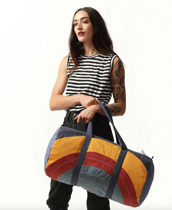 Woman holding fun rainbow tote by Anchal.