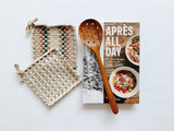 Apres all day cookbook paired with beautiful handwoven potholders and a teak strainer spoon.