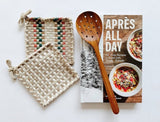 Apres all day cookbook paired with beautiful handwoven potholders and a teak strainer spoon.