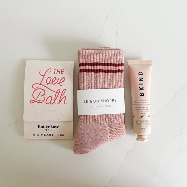 A packet of Butter Love Love Bath, girlfriend socks in salmon from Le Bon shop, and Kind hand cream.