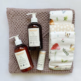 Loulou Lollipop washcloths in wooden adventure, magic linen waffle hooded towel, and erbaviva lotion and wash.