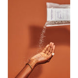 Bag of bath soak pouring into a hand.  Luxurious spa gift for friend.