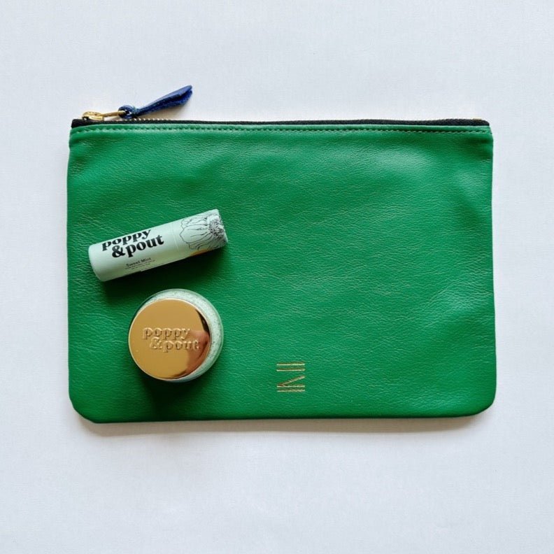 Green and beige leather pouch paired with poppy & pout products.