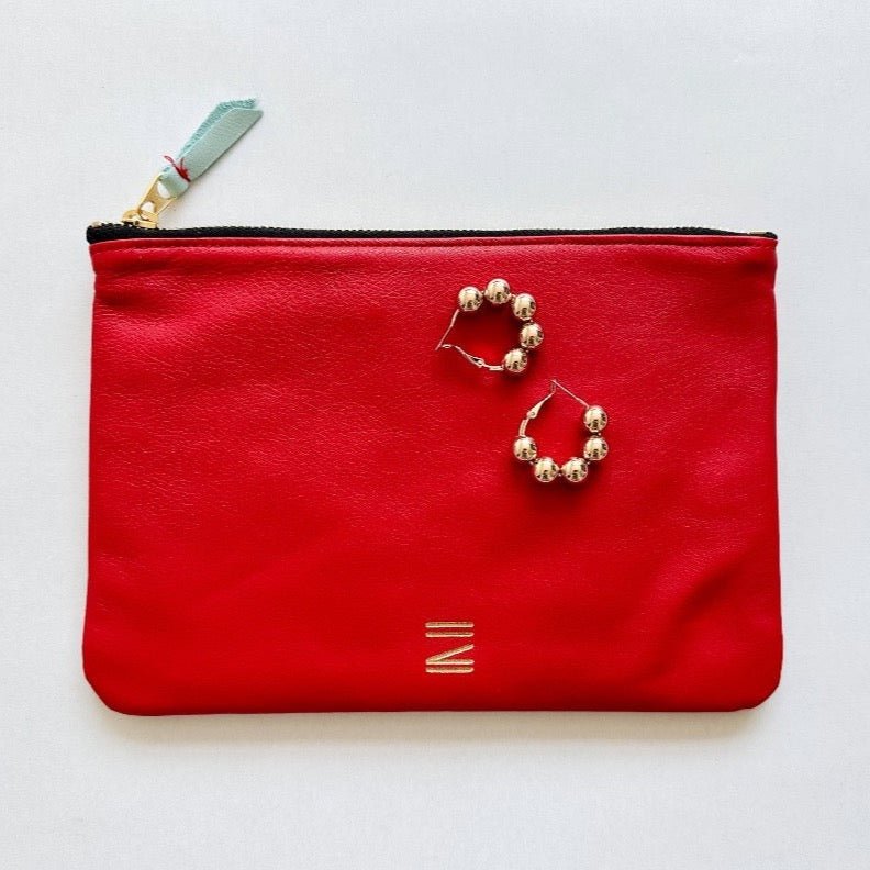 Red leather pouch from Certain Standard featured with Paloma earrings from Shashi.