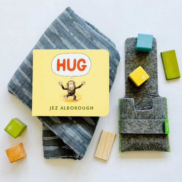 Muslin swaddle blanket paired with Hug book and Tegu blocks. A sweet kid's gift combination.