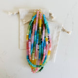 A stack of Etoiled ombre necklaces in a muted rainbow of hues.