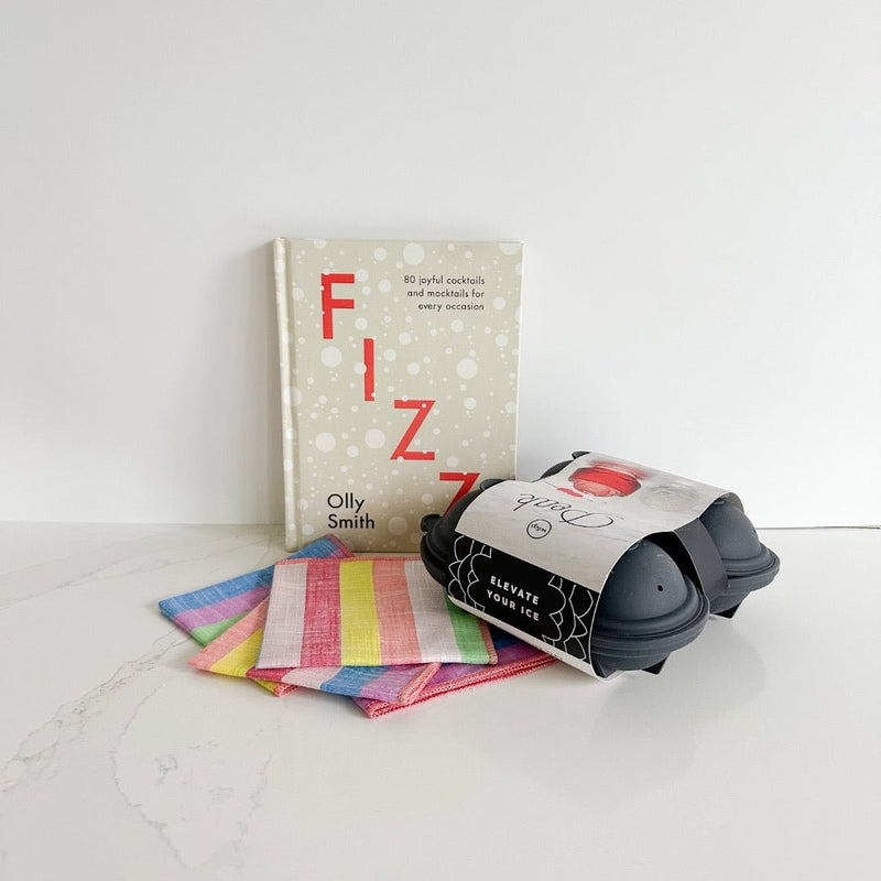 Fizz cocktail book pairs well with cocktail napkins and an ice cube tray.