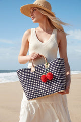 Woman on the beach holding the Hadley tote.