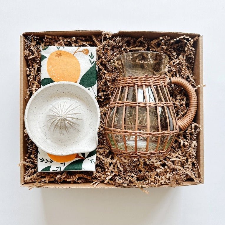 Hazelmade tea towel paired with a handmade ceramic juicer and rattan pitcher.