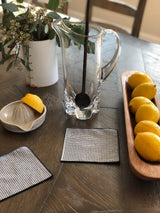 Pretty table featuring ovalado bowl filled with lemons, a pitcher and lemon juicer.