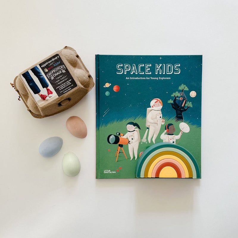 Space Kids book for young explorers paired with sidewalk chalk and a rainbow stacker. Let the adventures begin