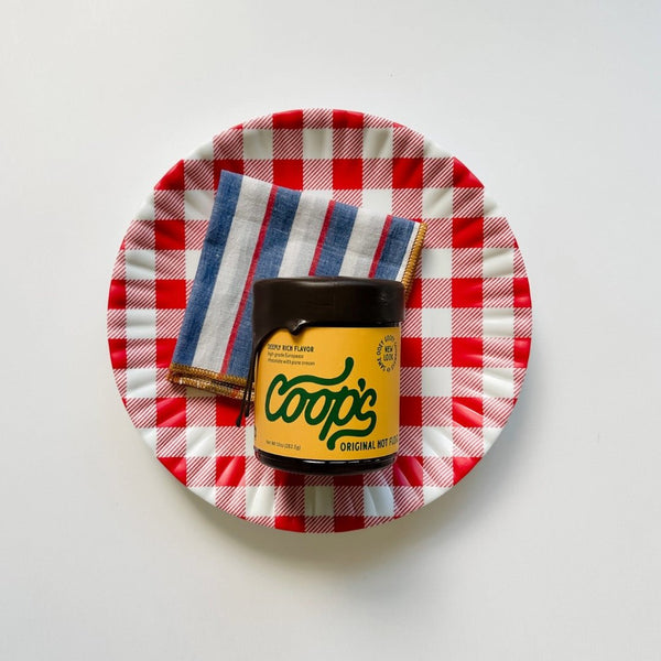 The perfect host gift featuring Coop's original hot fudge, willow ship napkins and red-checkered melamine plates.