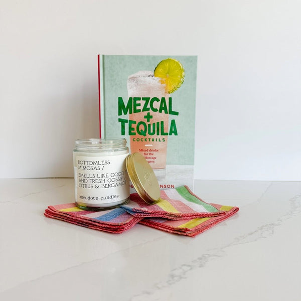 Mezcal + Tequila cocktail recipe book makes the cutest host gift with this bottomless mimosa candle and Rainbow Sherbet cocktail napkins from Willow Ship.
