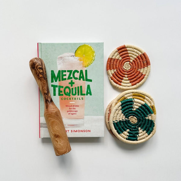 A great host gift includes this Mezcal + Tequila cocktail book, an olive wood muddler, Kazi serotonia coasters.