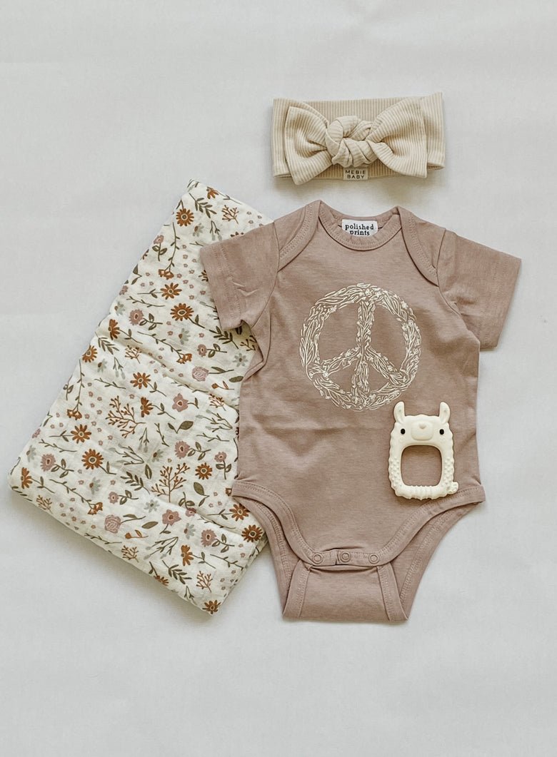 Fawn peace floral onesie from polished prints paired with the Mebie baby ivory head wrap and meadow floral muslin swaddle makes an amazing baby gift.