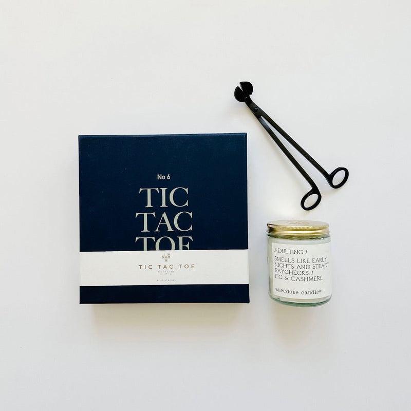Gift inspiration with a nave blue tic tac toe box set, an Adulting candle from Anecdote candles, and wick trimmers complete this fun little host gift.