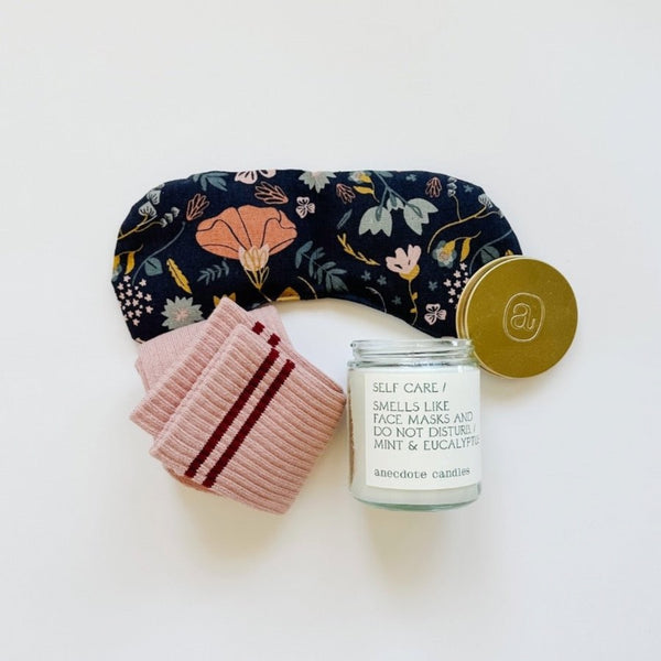 A sweet floral design in muted tones on this navy eye therapy mask. Girlfriend socks from Le Bon Shoppe and a Self-care candle from anecdote candle.