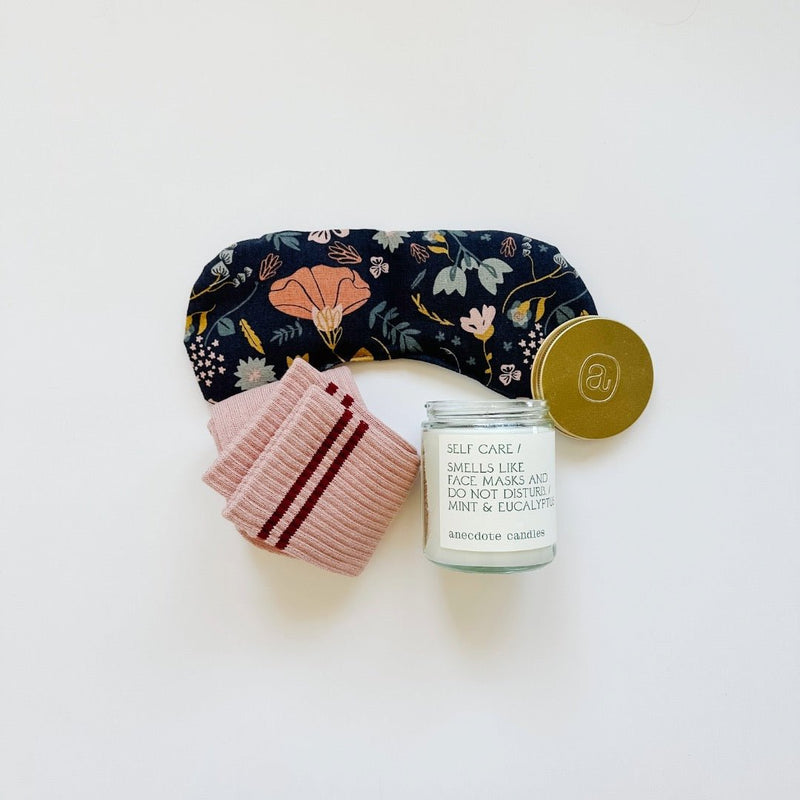 A sweet floral design in muted tones on this navy eye therapy mask. Girlfriend socks from Le Bon Shoppe and a Self-care candle from anecdote candle.