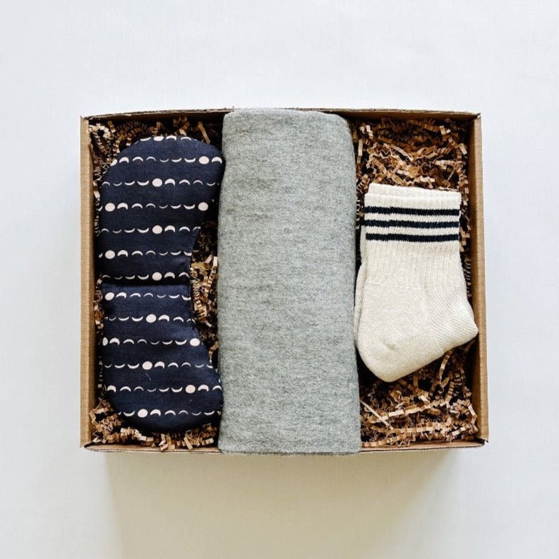Packed together in a box, Tbco gray scarf paried with a slow north eye mask and le bon shoppe socks.