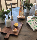 Tablescape with oil cruet, wooden board and cookbooks.
