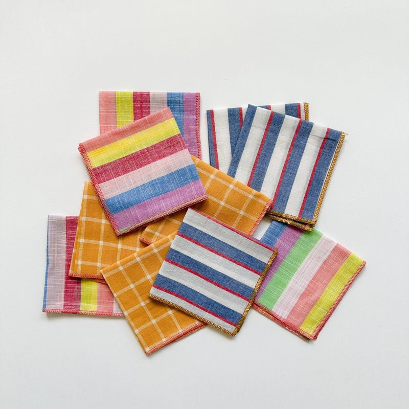 A collection of Willow Ship cocktail napkins in stripes and checks including the Mondrian Striped, Teach Windowpane, and Rainbow Sherbet napkins.